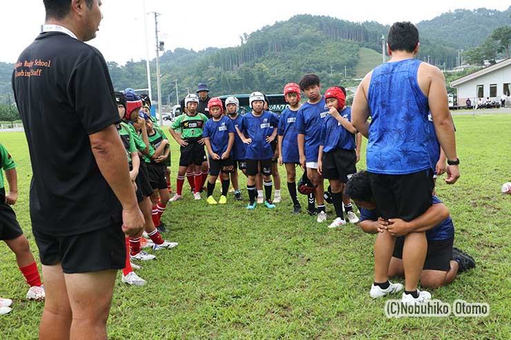 Acorns中村コーチのタックル指導を熱心に聞く小学生たち