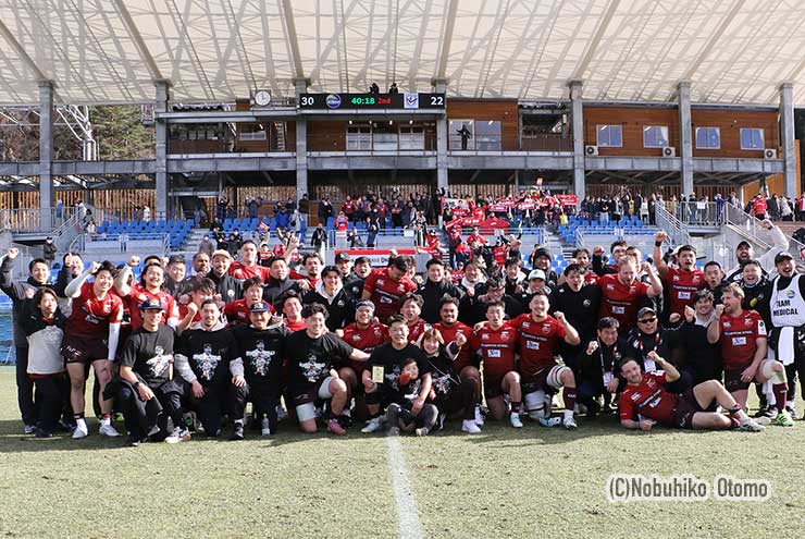 スタンドのファンと一緒に勝利の記念写真